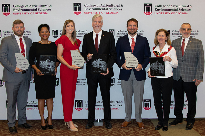 2023 alumni award winners and the college dean stand and pose for a photo.
