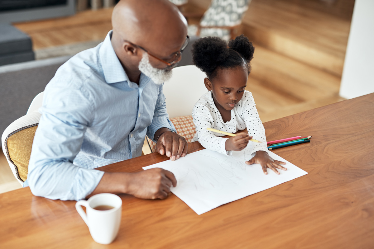Grandparent helping child learn to write