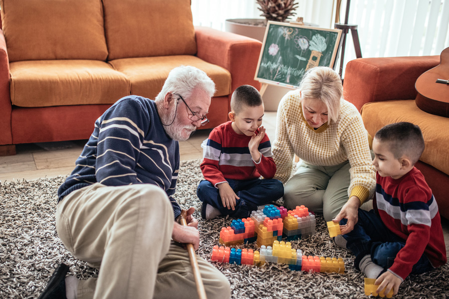 Grandparents and grandchild playing with building blocks.