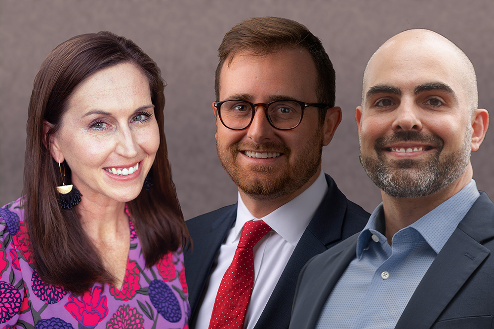 Three professionally dressed individuals smiling, posing against a neutral background.