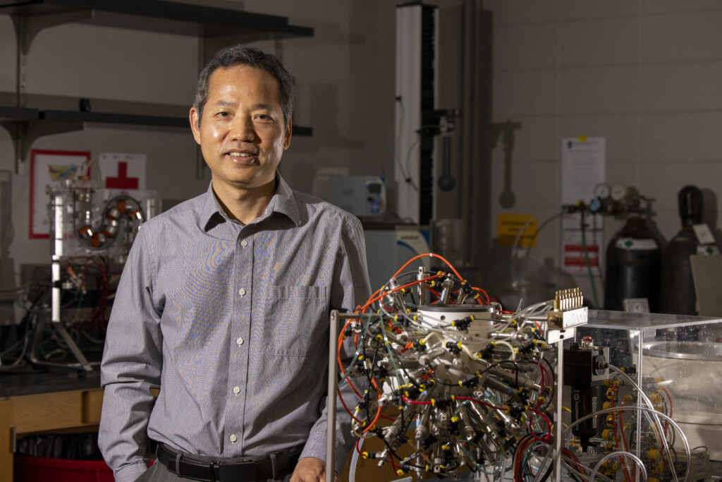 Fanbin Kong smiles next to a gastric simulation model in his UGA lab