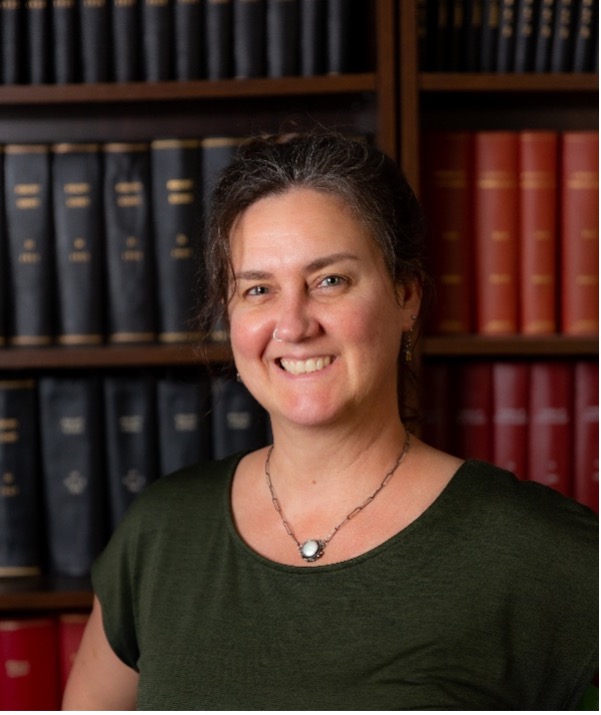 Laura Ellestad smiles in front of shelves full of books