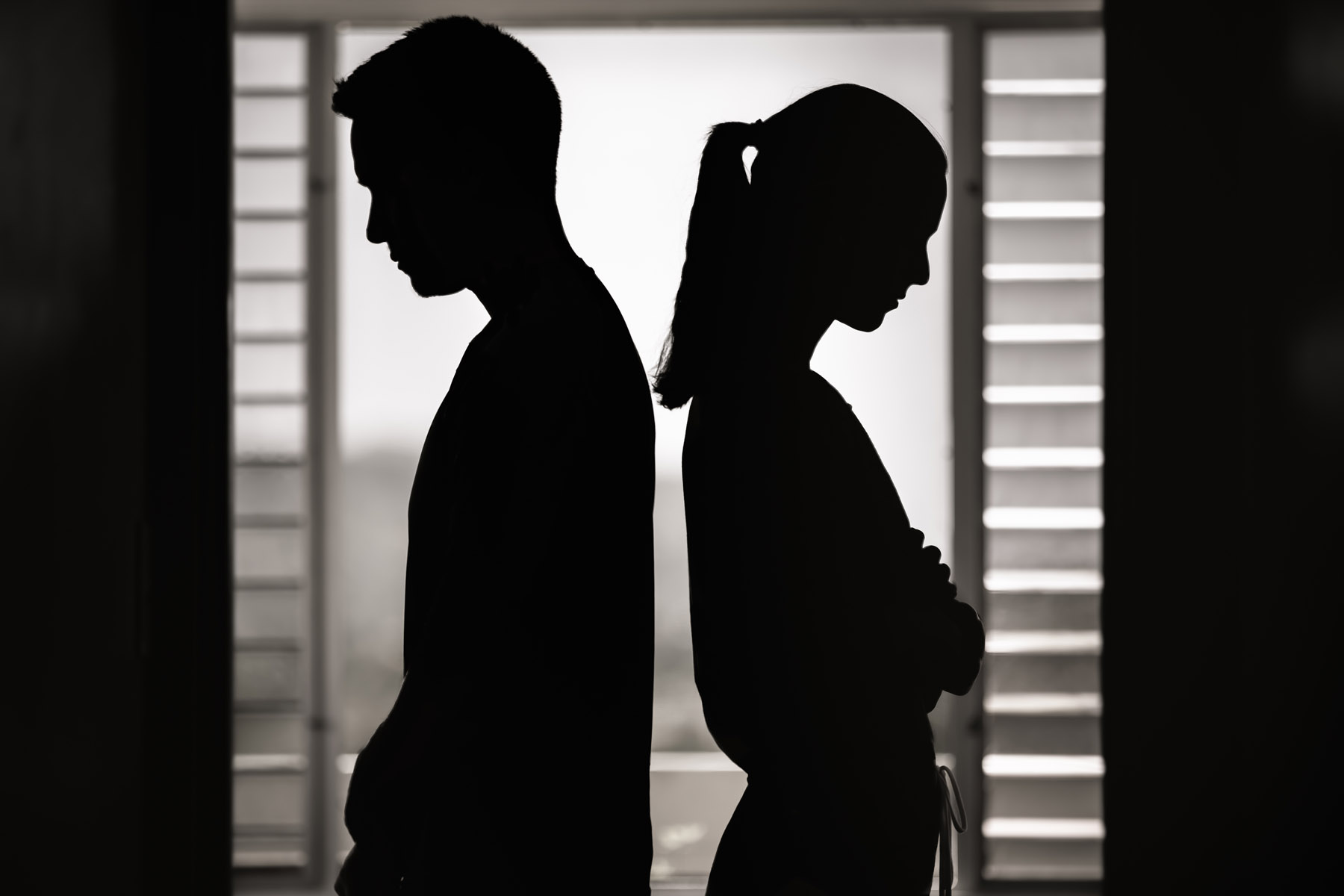 An abstract photo of two people in silhouette with their backs turned to each other