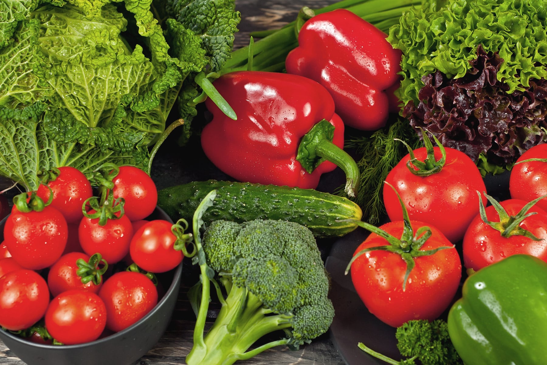 bright red tomatoes and peppers with green broccoli, lettuces, and cucumbers