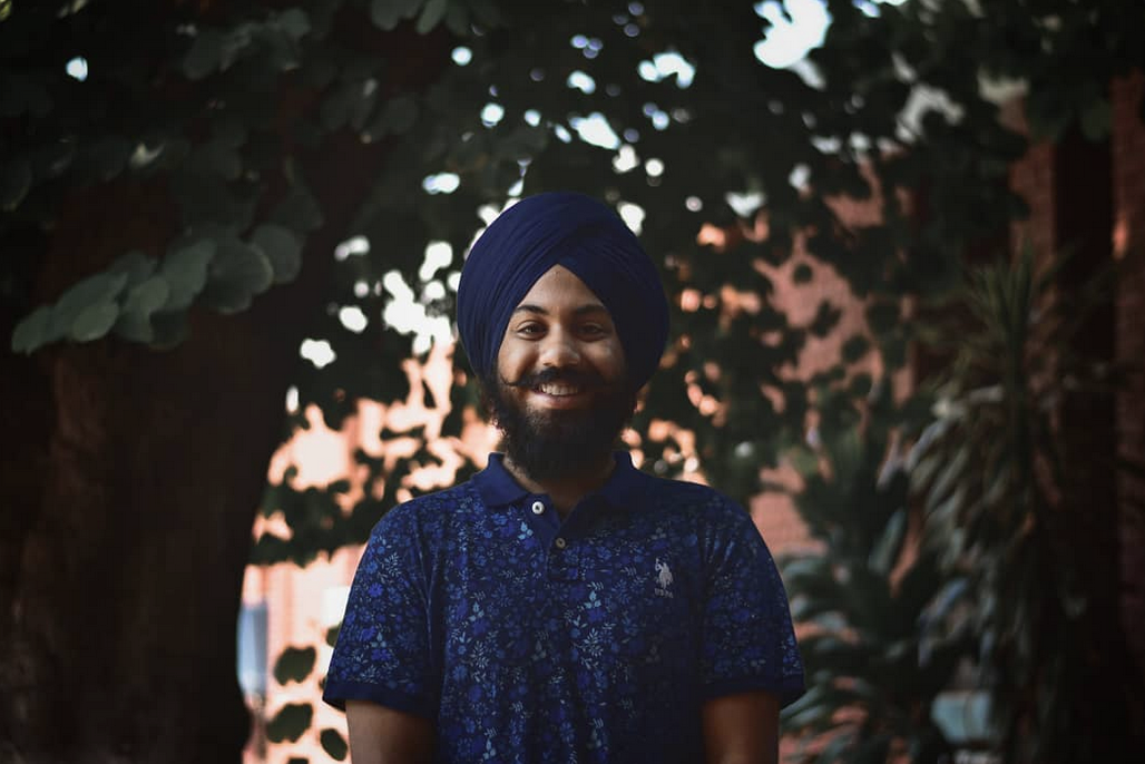 Sunaab Kukal smiles while standing among trees