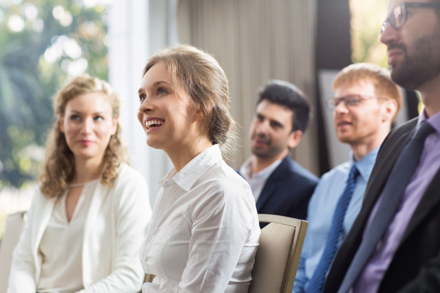 People engaging and smiling in a group meeting.