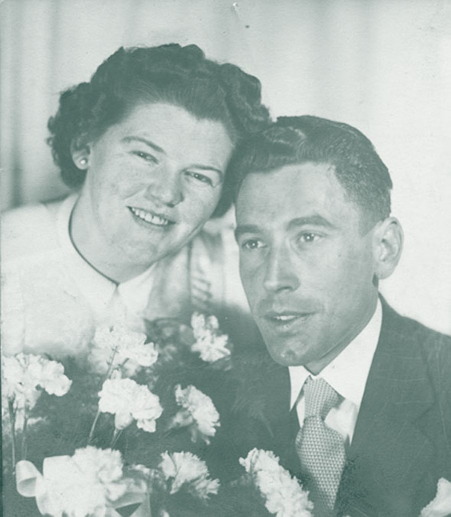 Wedding photo of Hans and Magrit Broder holding a bouquet of flowers between them