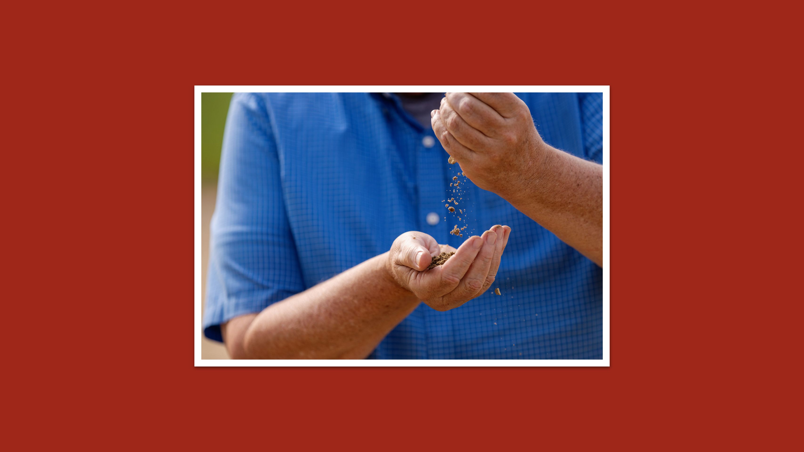 A man gently passes sand between his hands