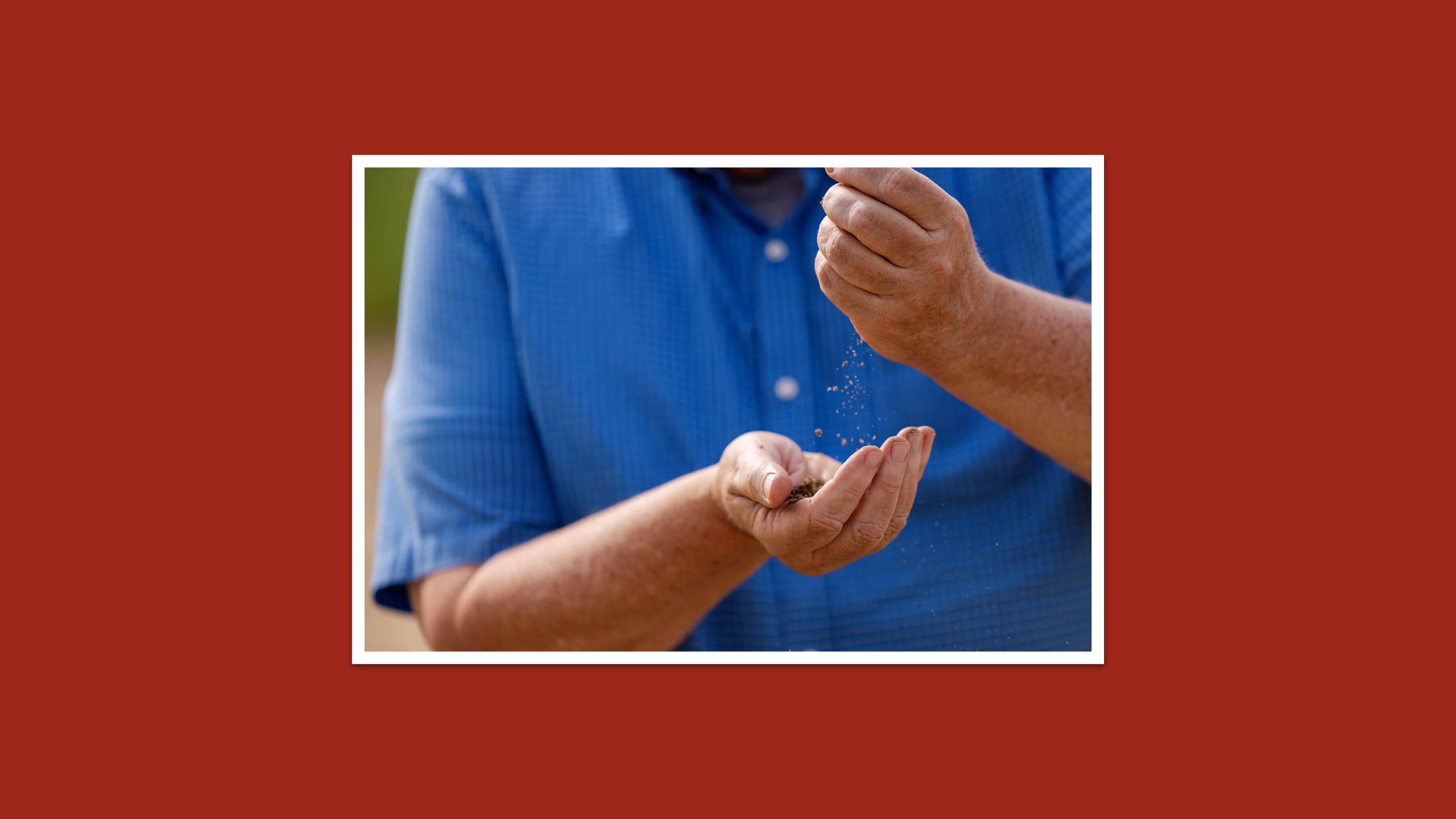A man gently passes sand between his hands