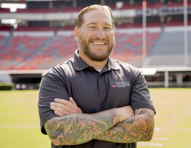 A man in a gray University of Georgia polo standing in Sanford Stadium