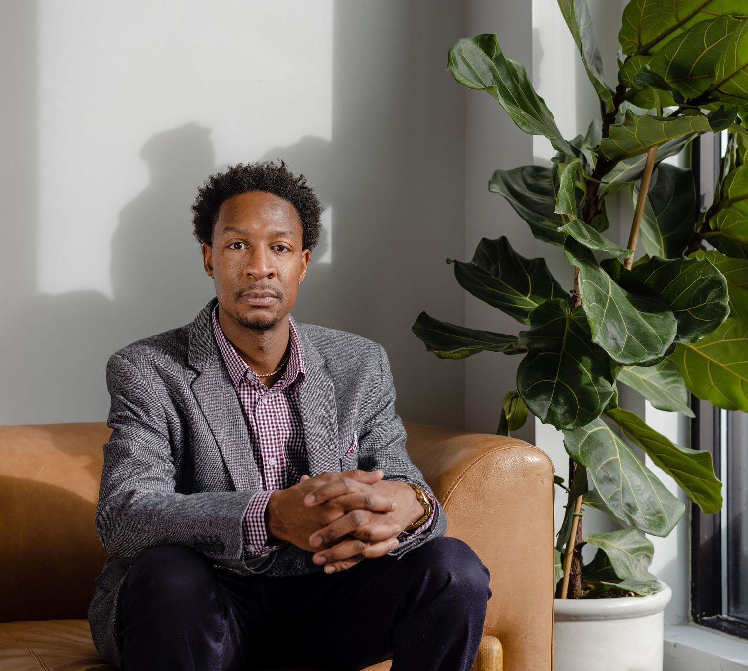 Marcus Jones in professional wear sitting on a couch