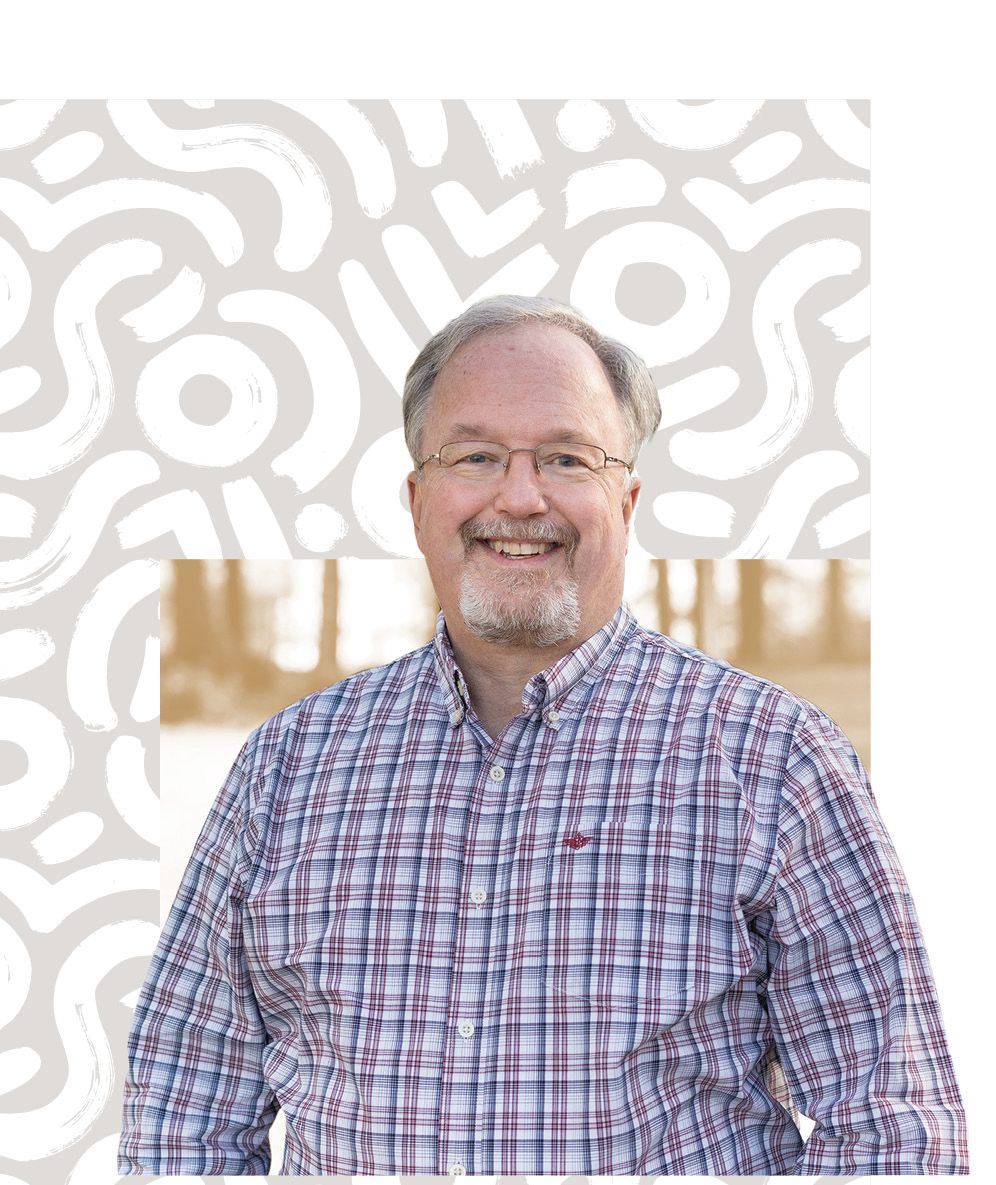 Tim Miller, CAES Alumni Board president, smiles for the camera in a plaid shirt.