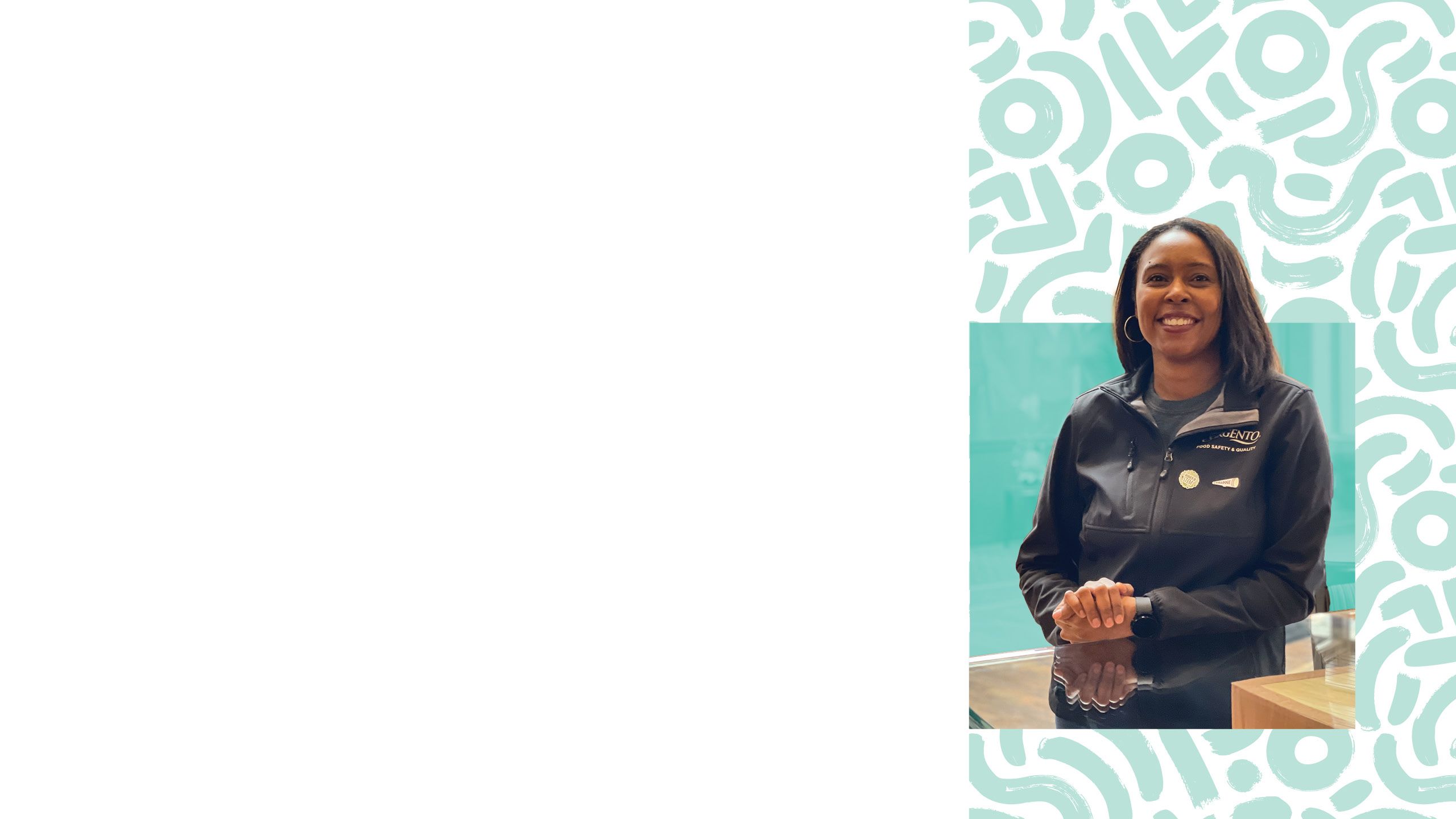 Takiyah Ball, microbiologist at Sargento, smiling at the camera in a black half-zip coat that says Sargento on it.