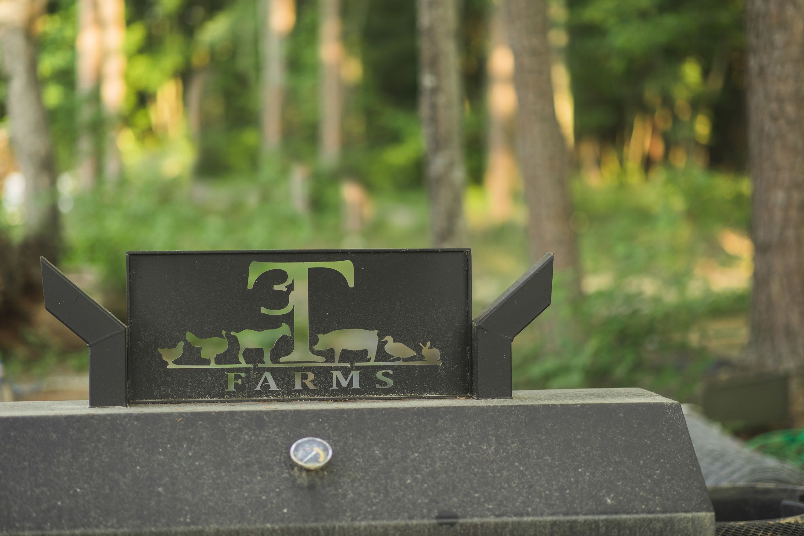 A black metal sign that says "T farms" on it.