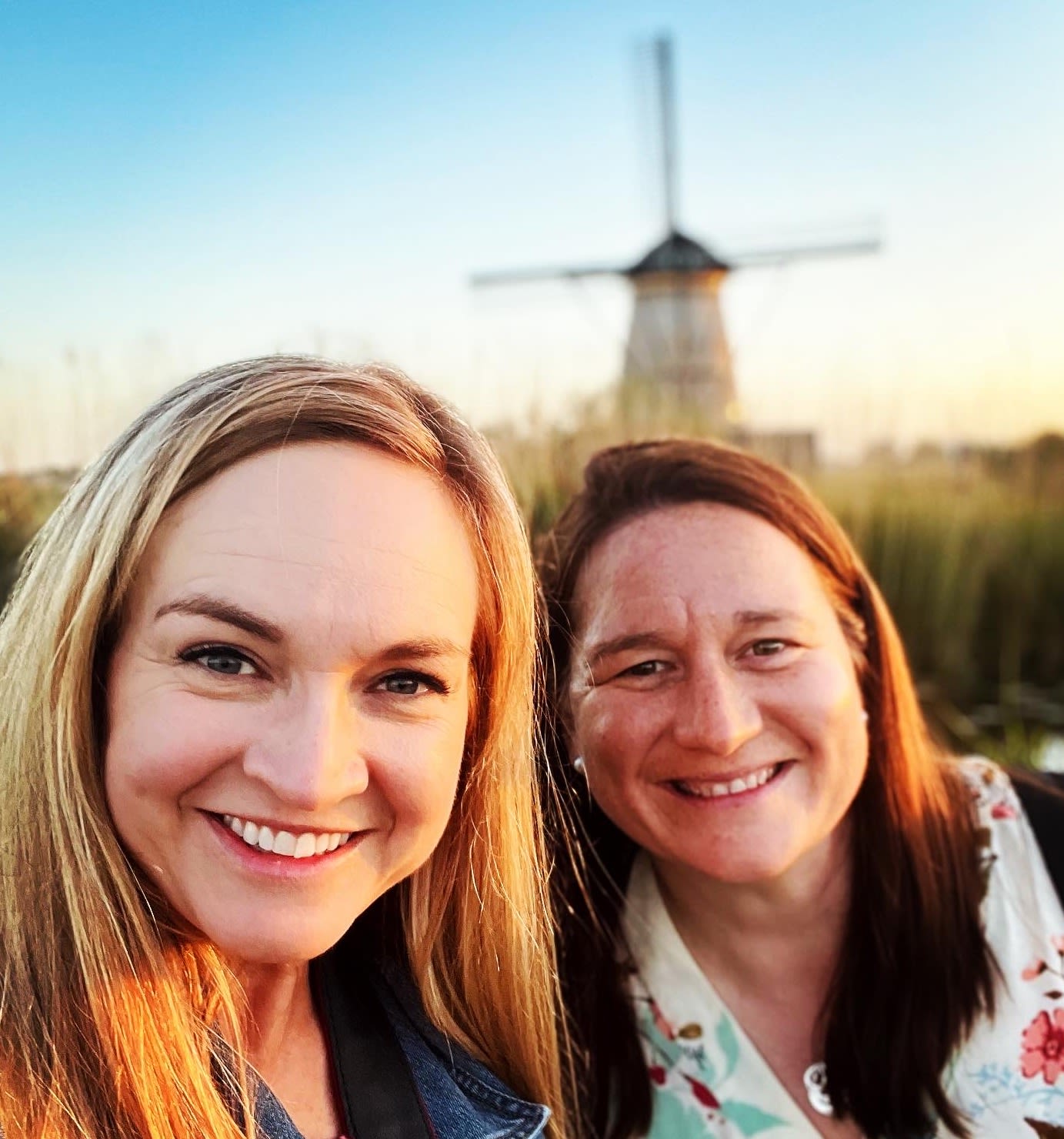 Two CAES faculty smile with a windmill in the background