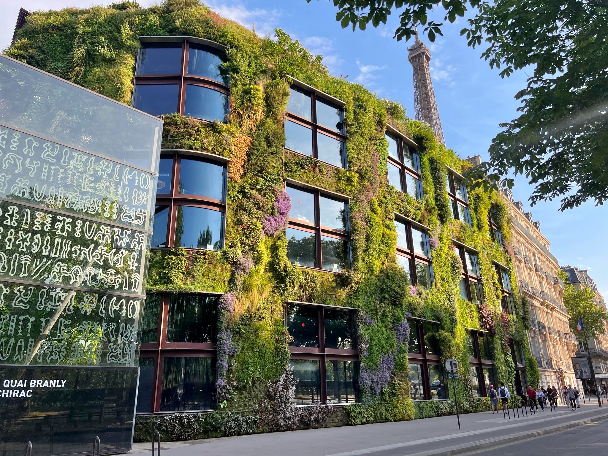 Plants grow on the side of a three-story building, creating living exterior walls