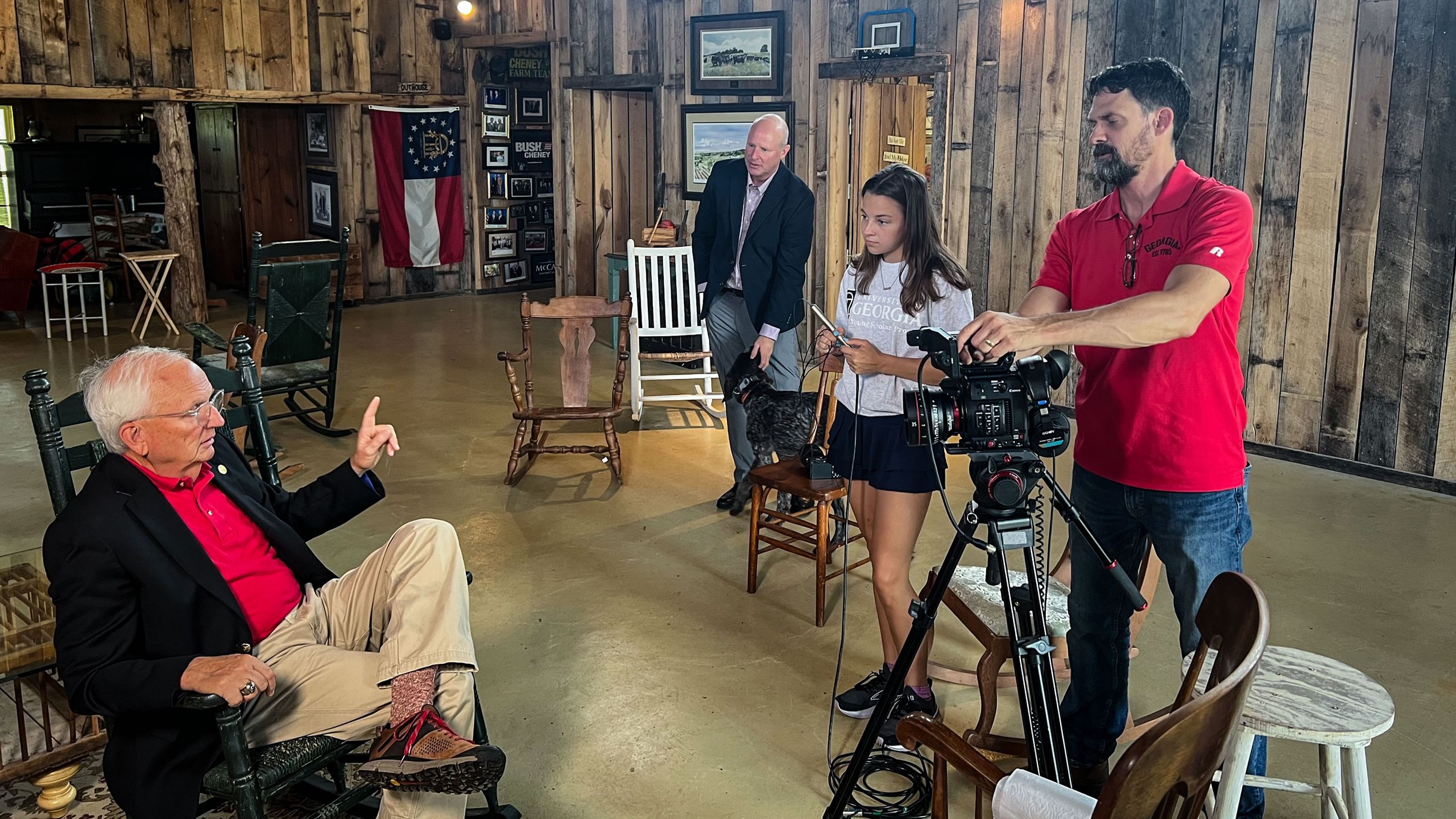 Jane Monachello and Anthony Barkdoll record video of Gary Black in a cabin set.