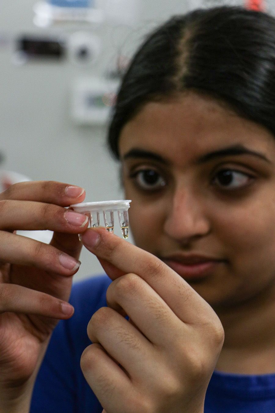 Venya Gunjal holds up tubes of clear liquid.