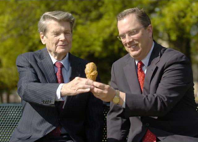 Massey and Mike Giles exchange a fried chicken drumstick.