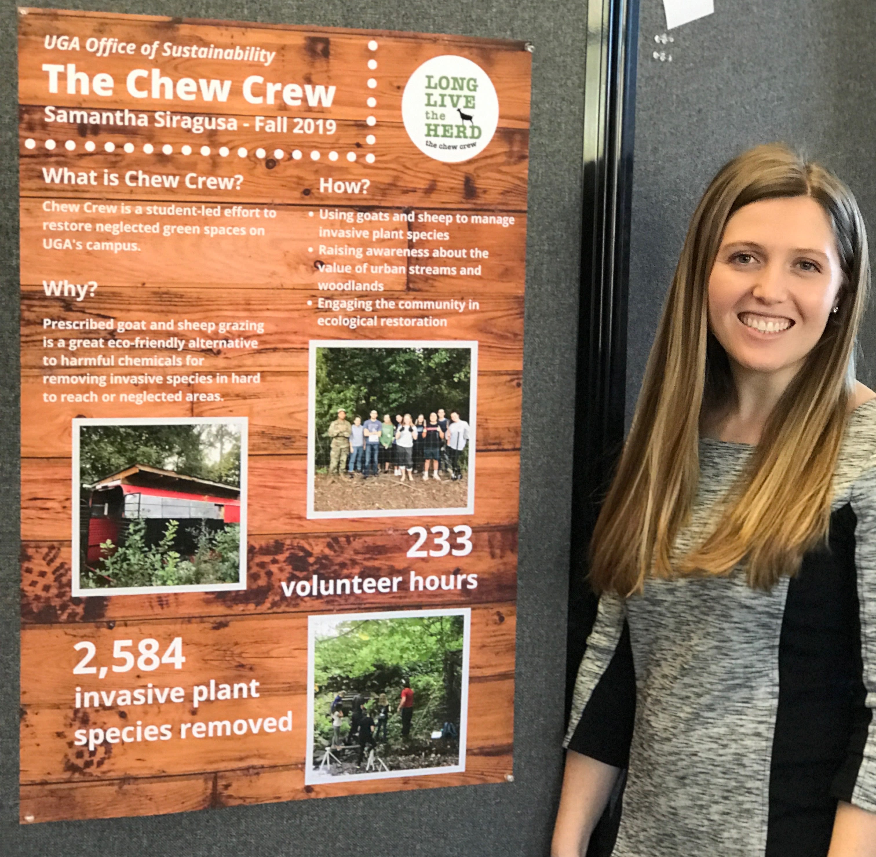 Samantha Siragusa smiles next to a poster for UGA's Chew Crew of goats