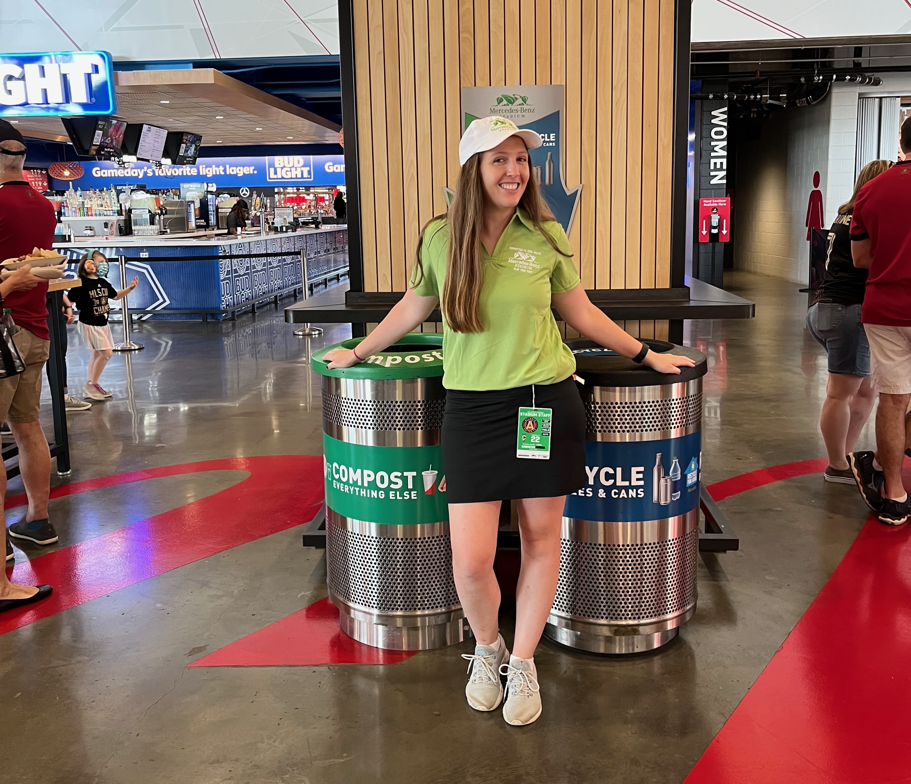 Siragusa poses with compost and recycling bins while volunteering