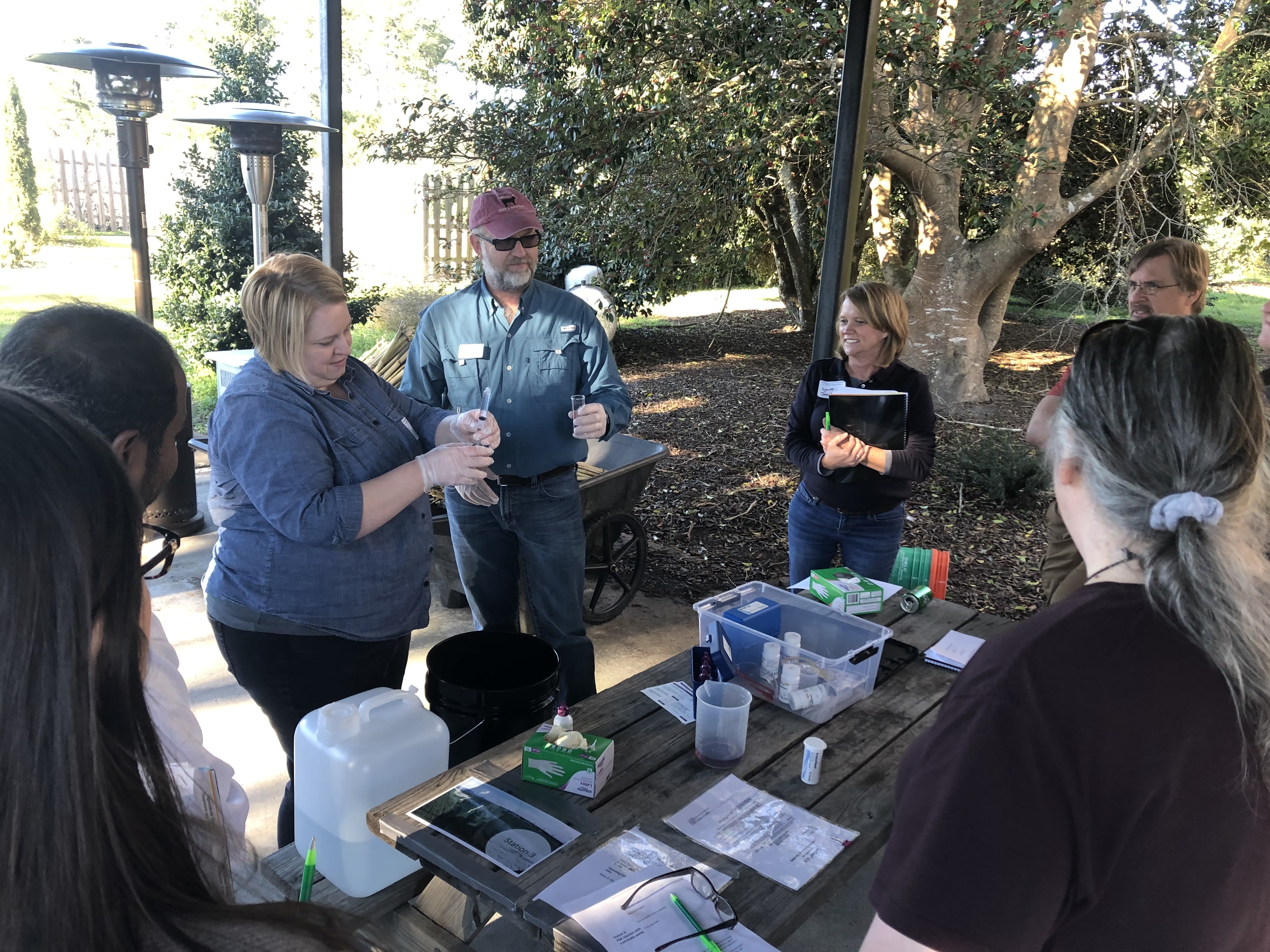 Critizer demonstrates lab work at an outdoor table