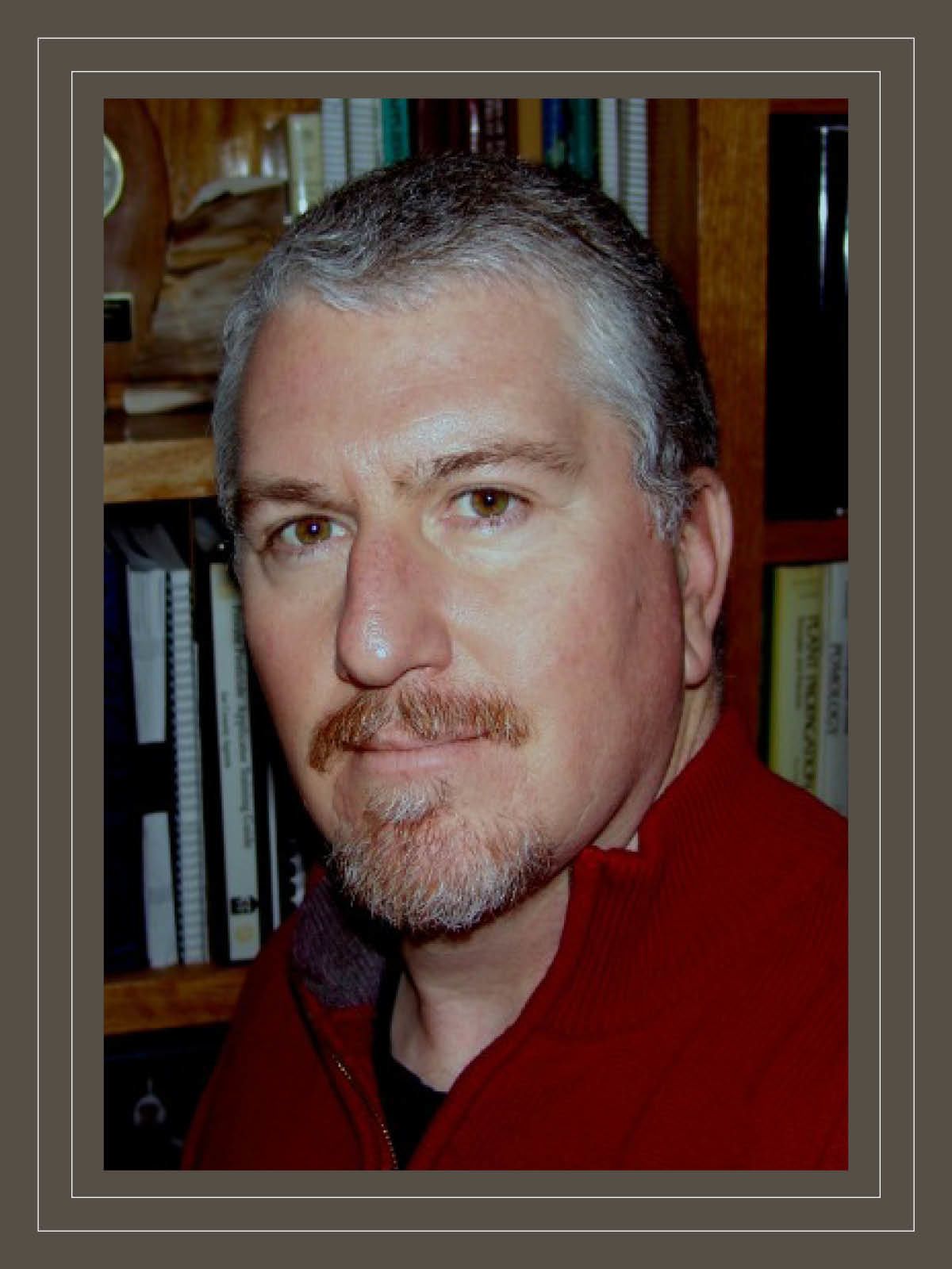 Headshot of Phil Brannen in front of a bookshelf
