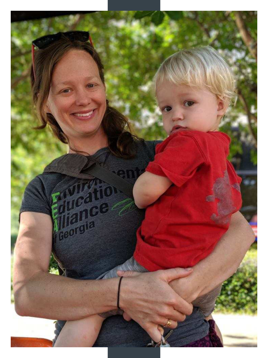 A woman holds a toddler on her hip