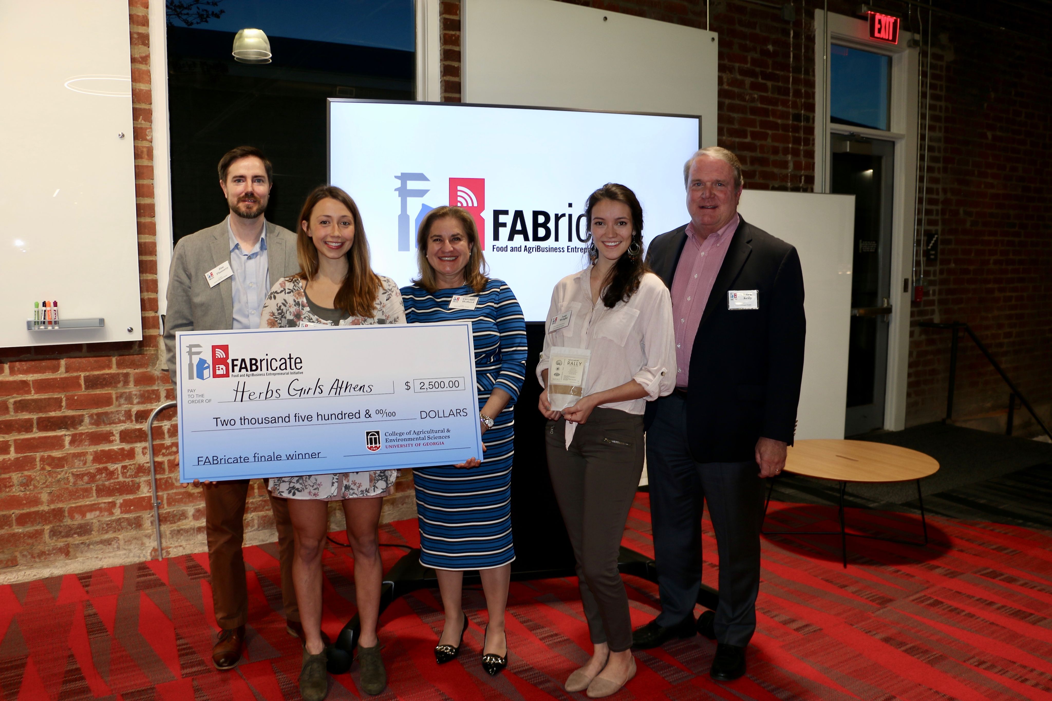 Group photo of five people holding a giant check