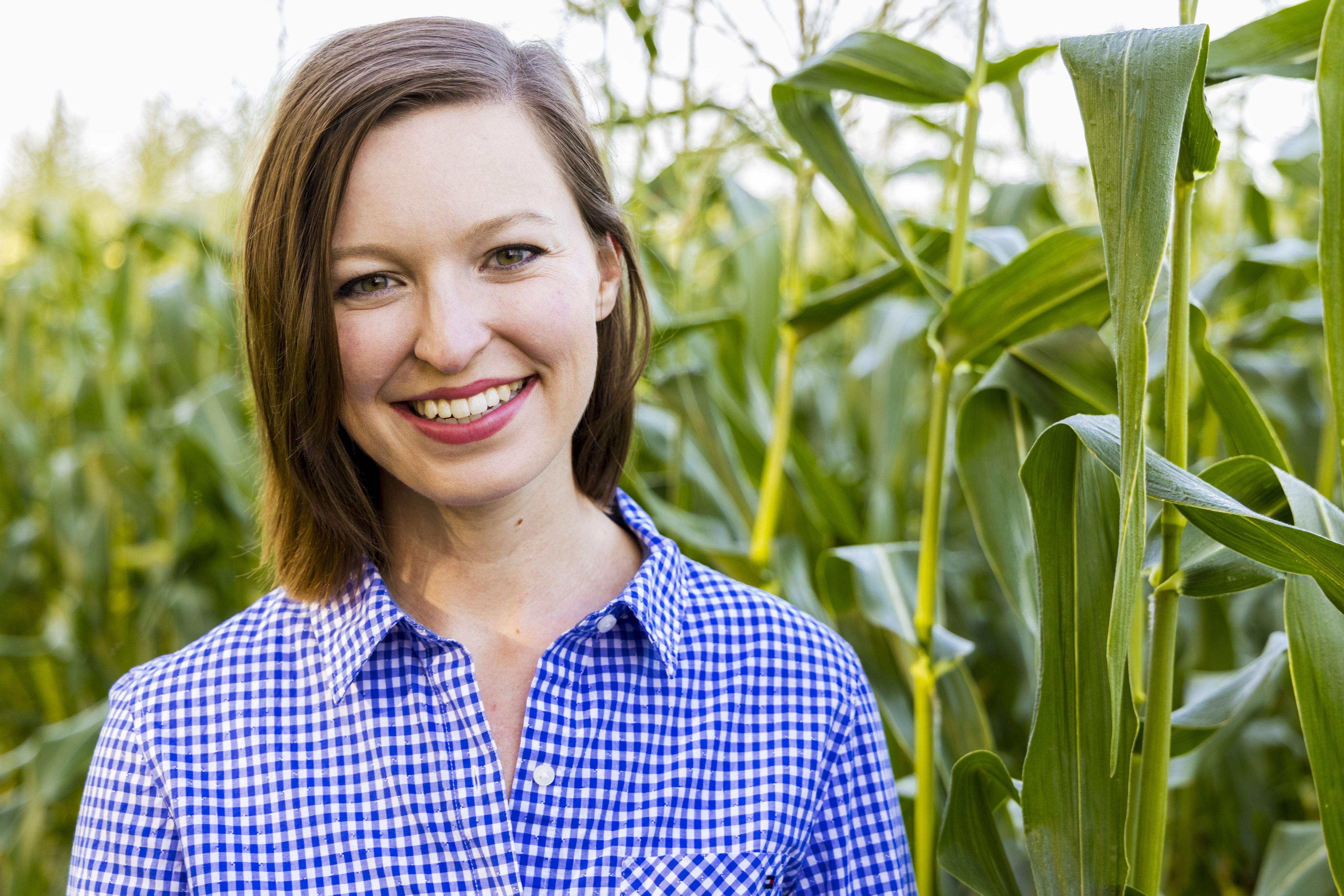 Headshot of smiling farmer in a corn field.