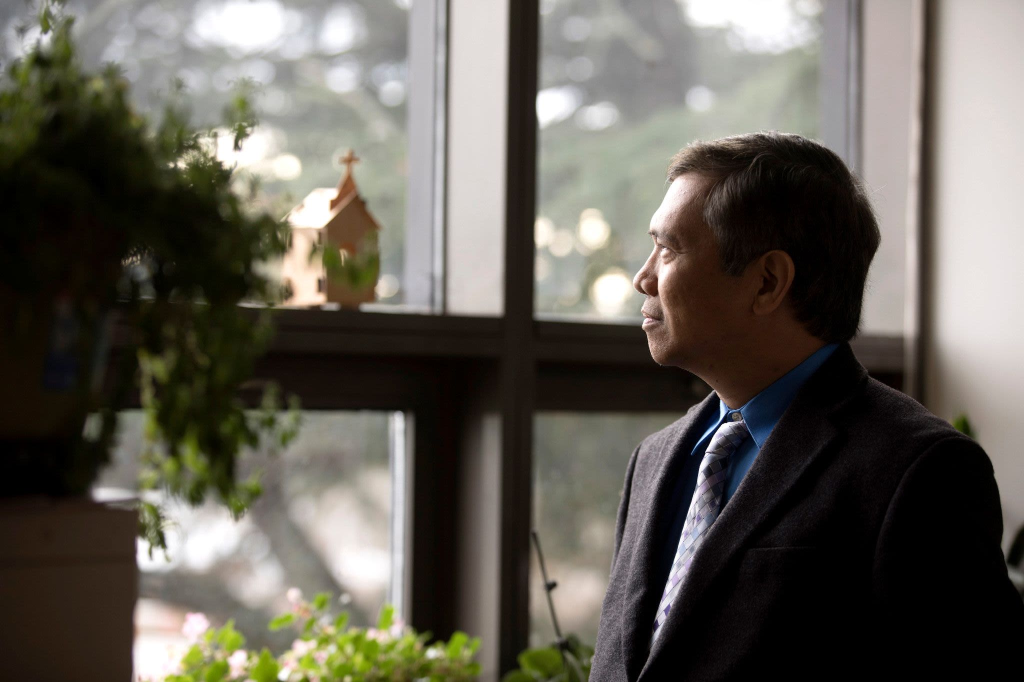 Man gazes out through window