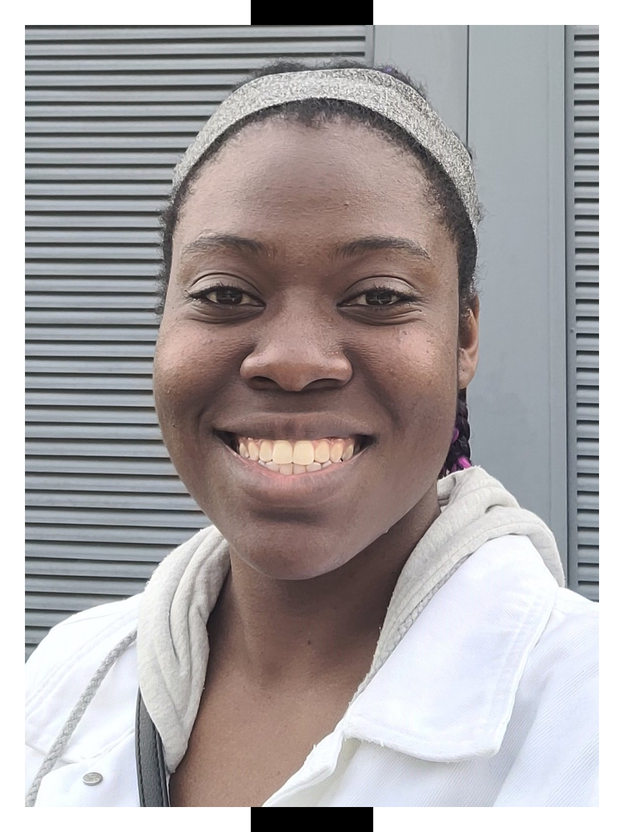 Wearing a white jacket, Ashley Lynch poses for a photo outdoors