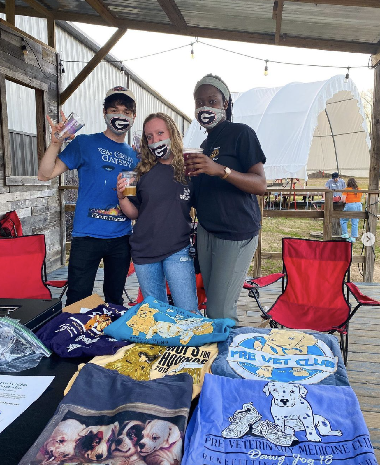 Wearing masks, Lynch and two students sell merch at a fundraising event at a local brewery
