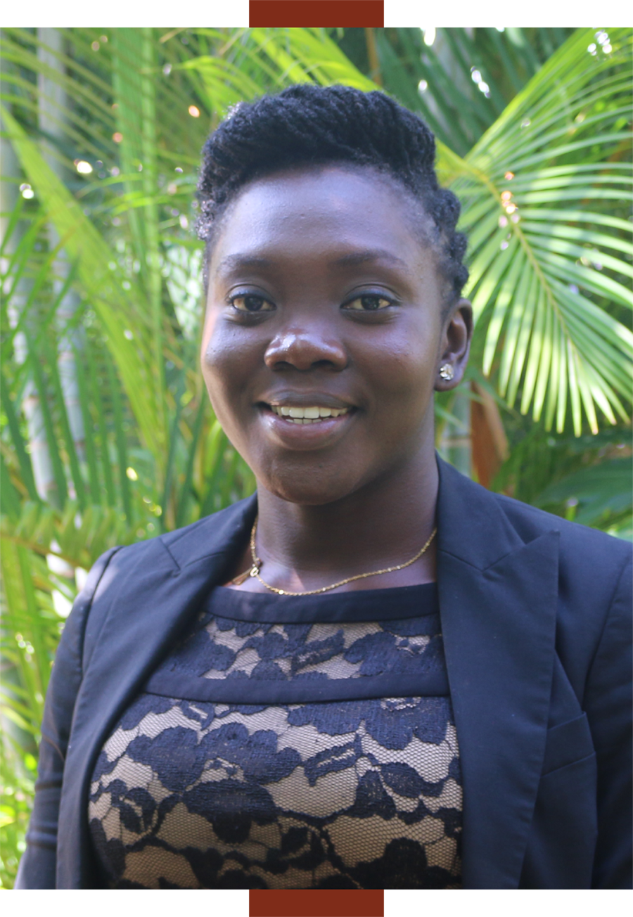 Danielle Essandoh smiles while standing in front of palm fronds