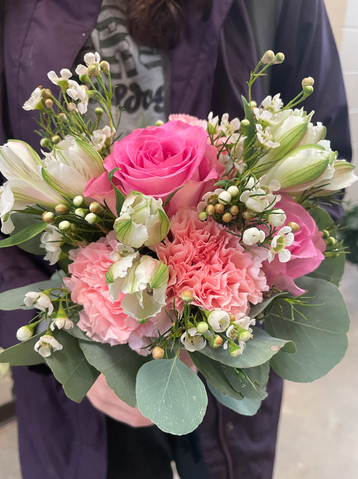 A bouquet of pink and white flowers with greenery.