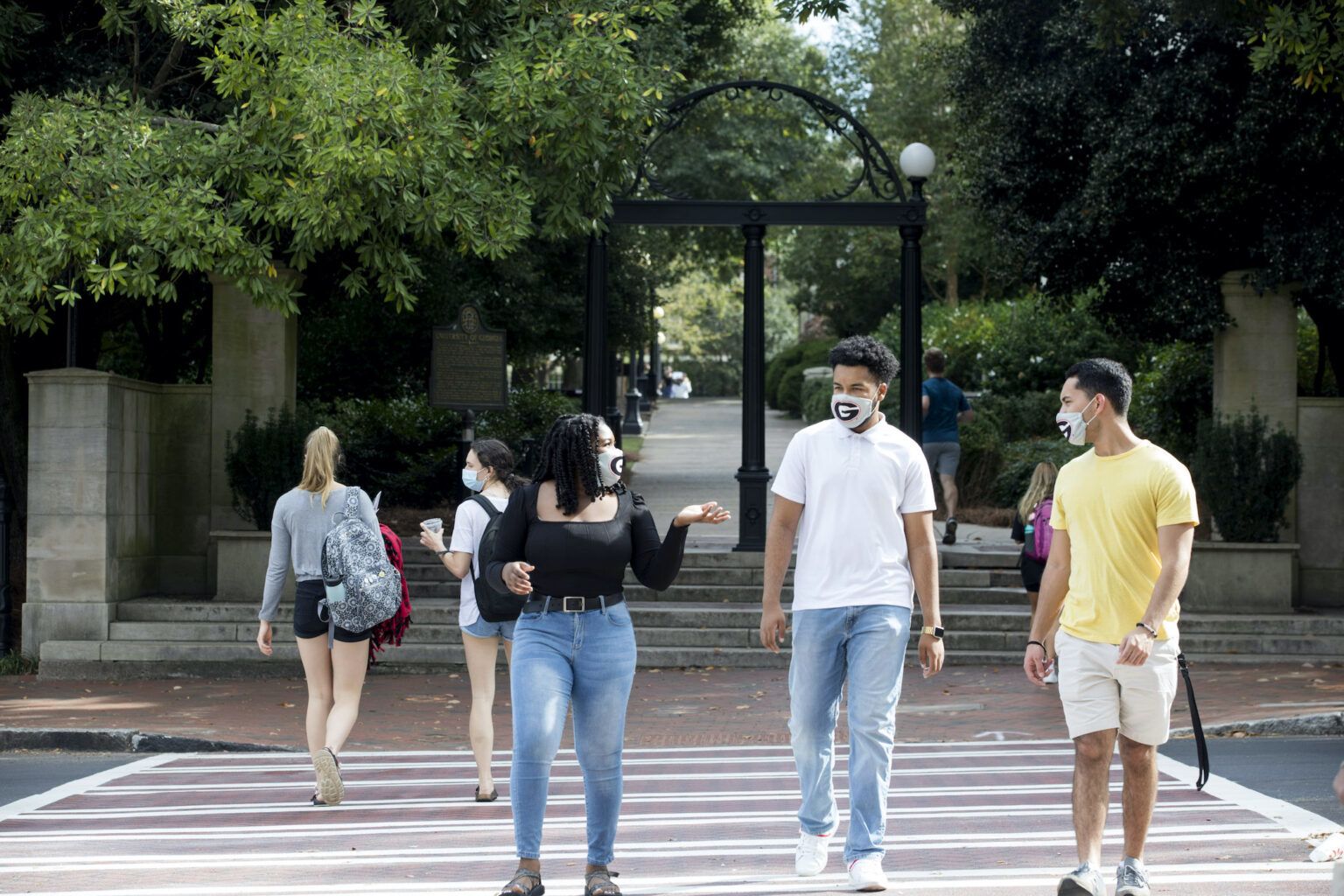 Students cross the street in front of UGA's Arch