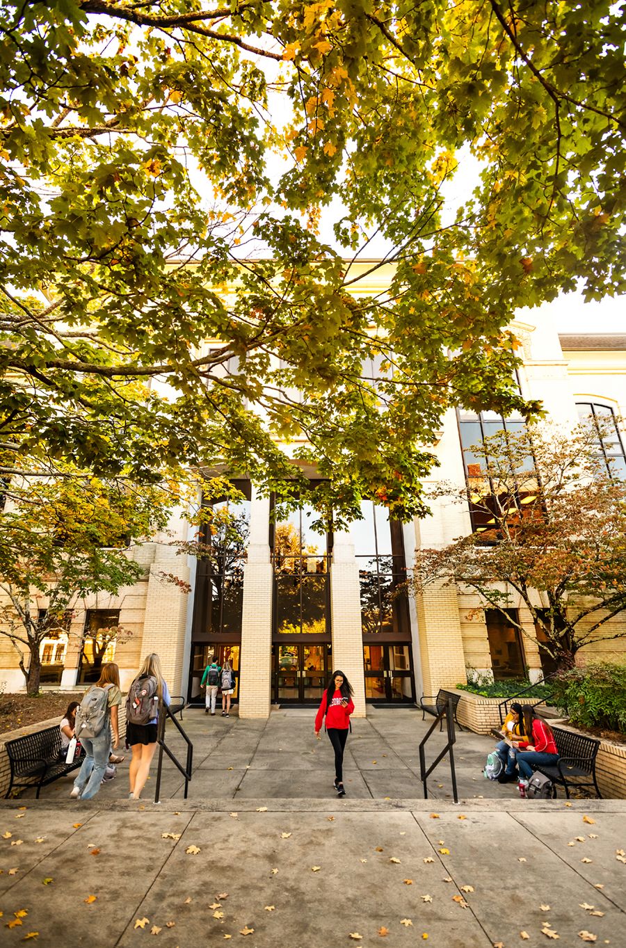 Students carrying backpacks head into and from Conner Hall 