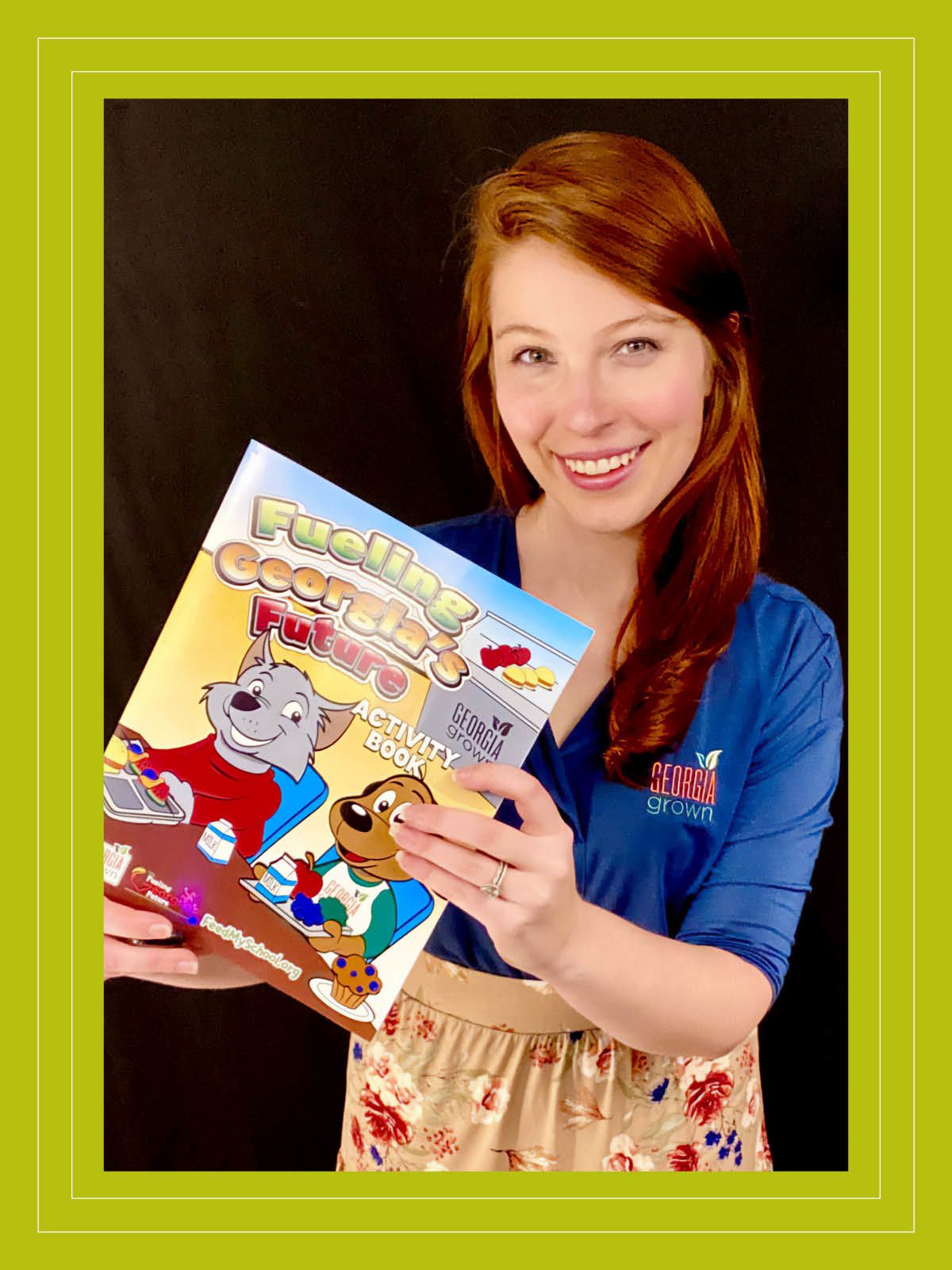 Standing against a black background and wearing a Georgia Grown polo shirt, Erin White shows off a "Fueling Georgia's Future" activity book