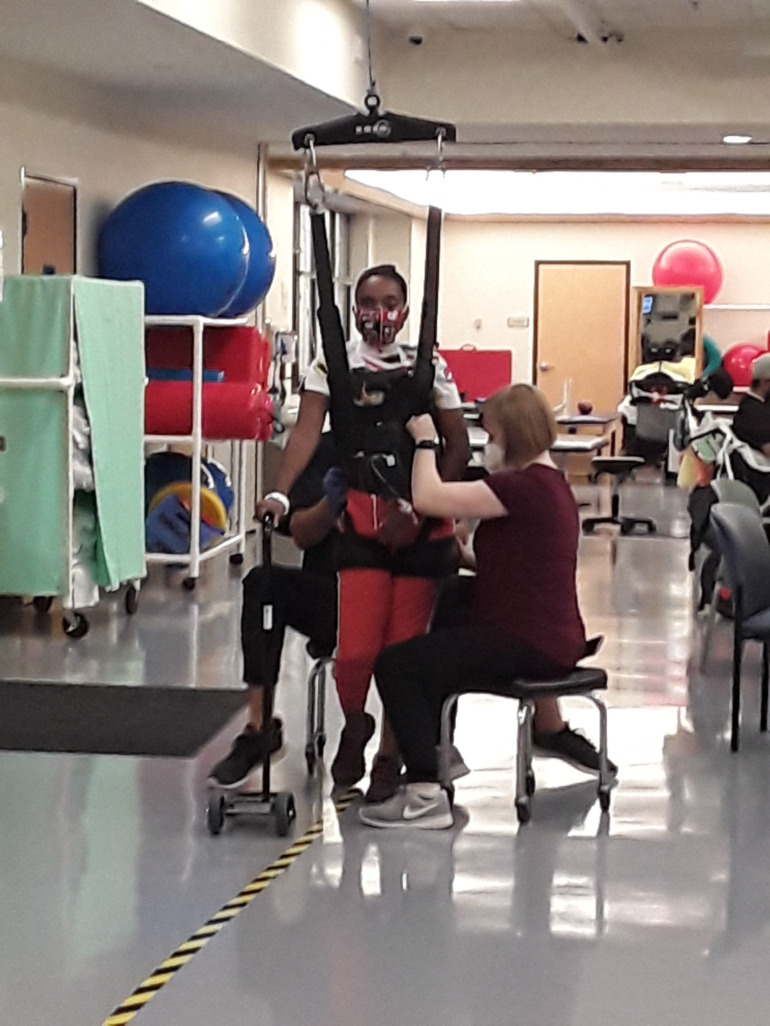 Therapists work with Phyllicia Thomas as she relearns how to walk using a lift at Atlanta's Shepherd Center. 