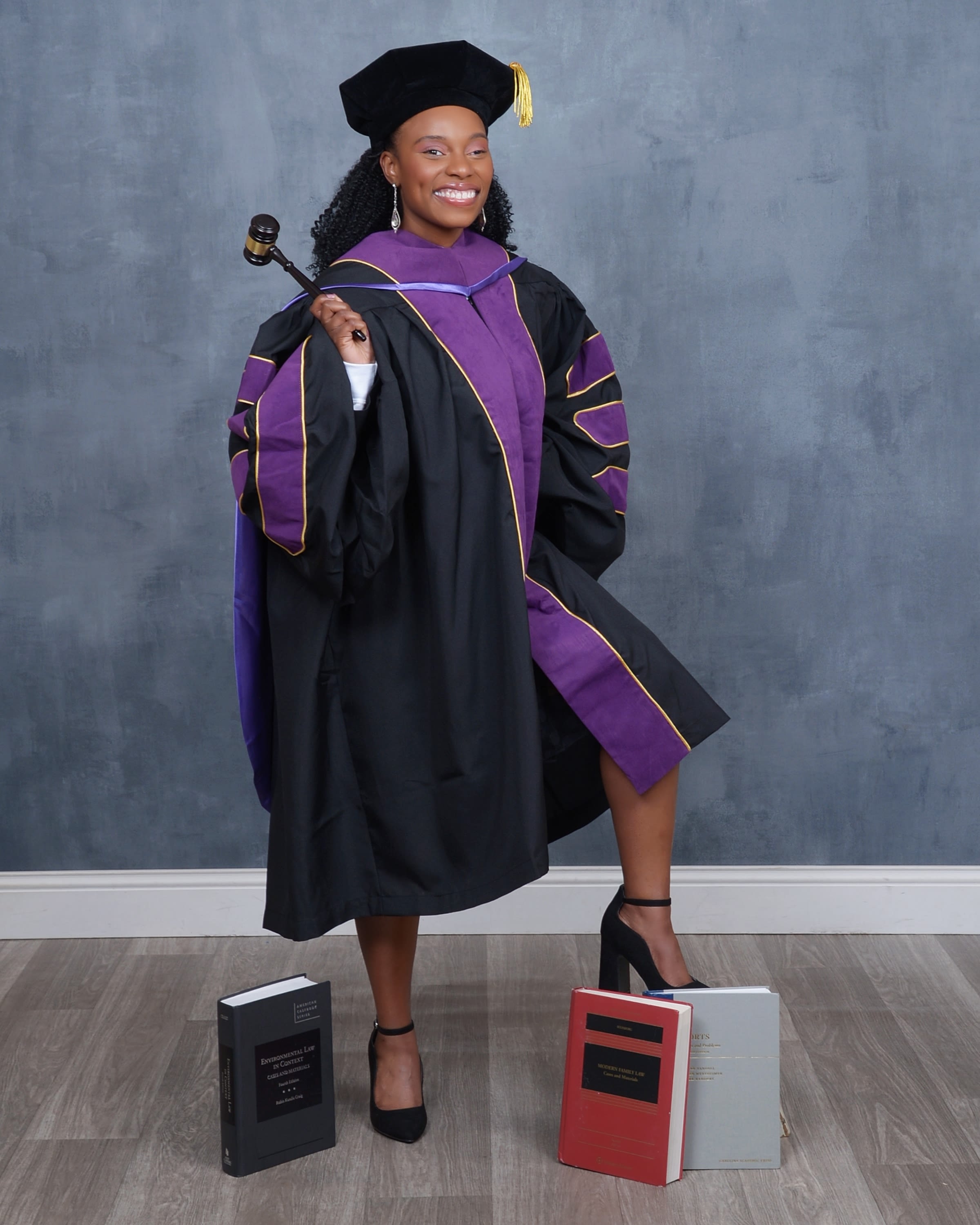 Phyllicia Thomas poses in her purple-trimmed formal robes in portraits celebrating her graduation from Emory University School of Law. 