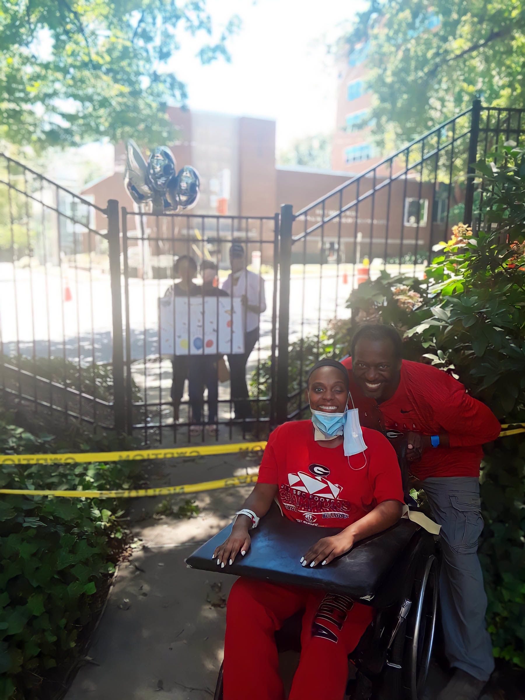 Thomas, in a wheelchair, and her father pose for a photo outside