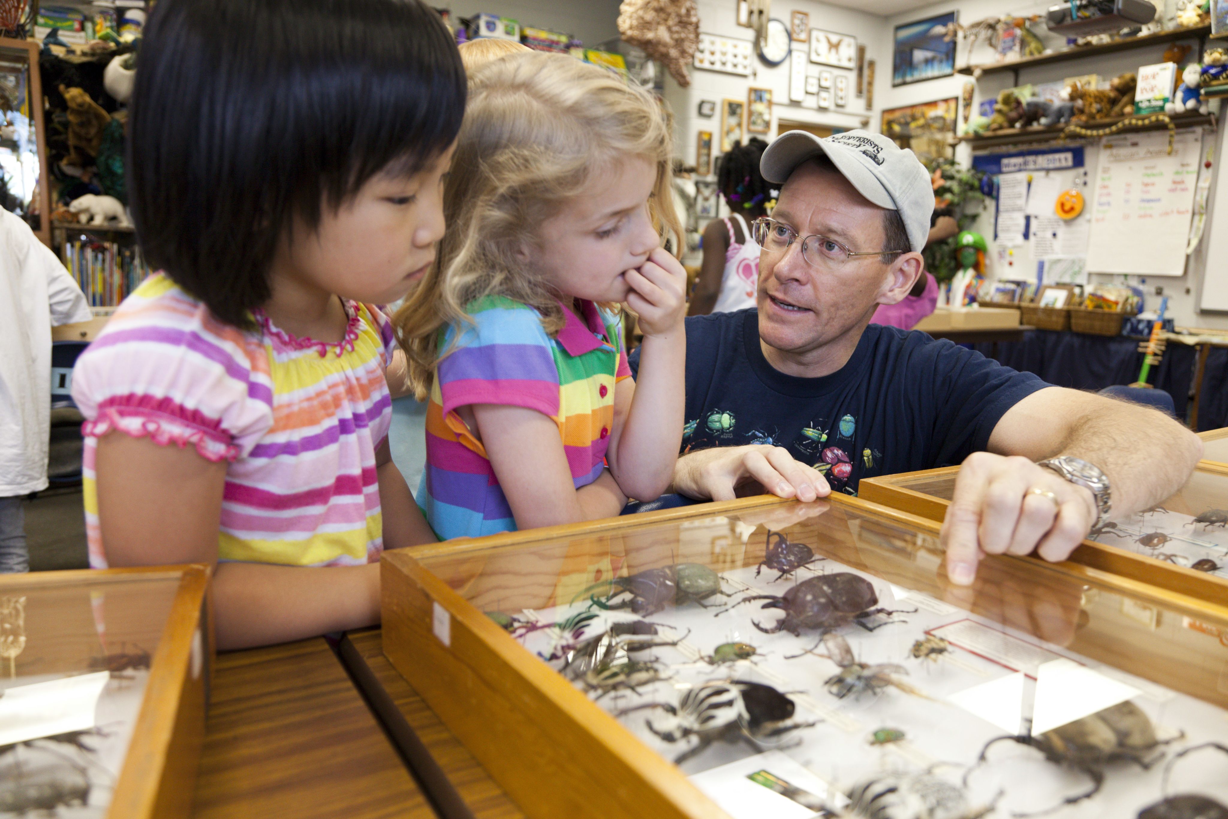 Man describes insect specimens to two children