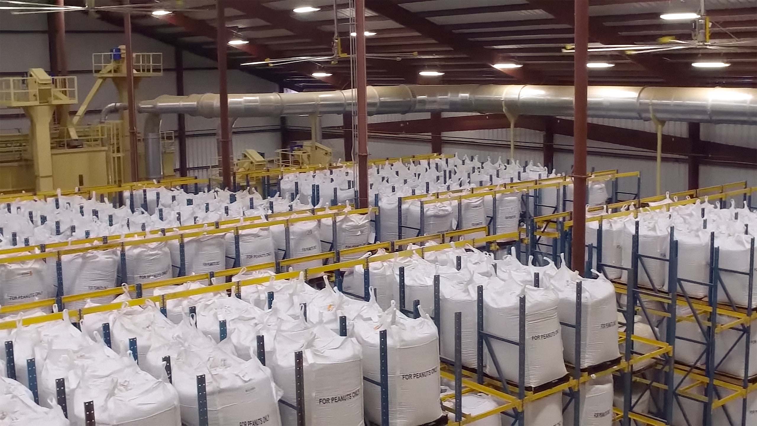 Ariel of a warehouse filled with rows of bags filled with peanuts.