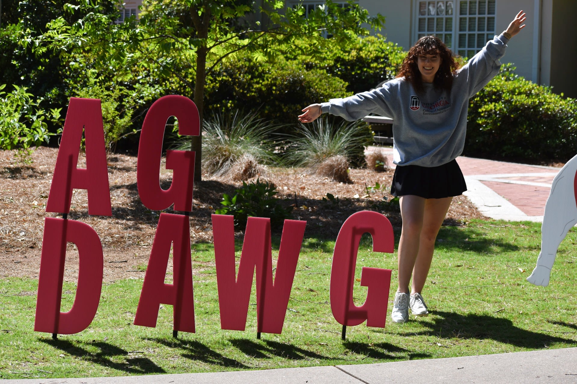 Swanger poses with an Ag Dawg sign on UGA's South Campus