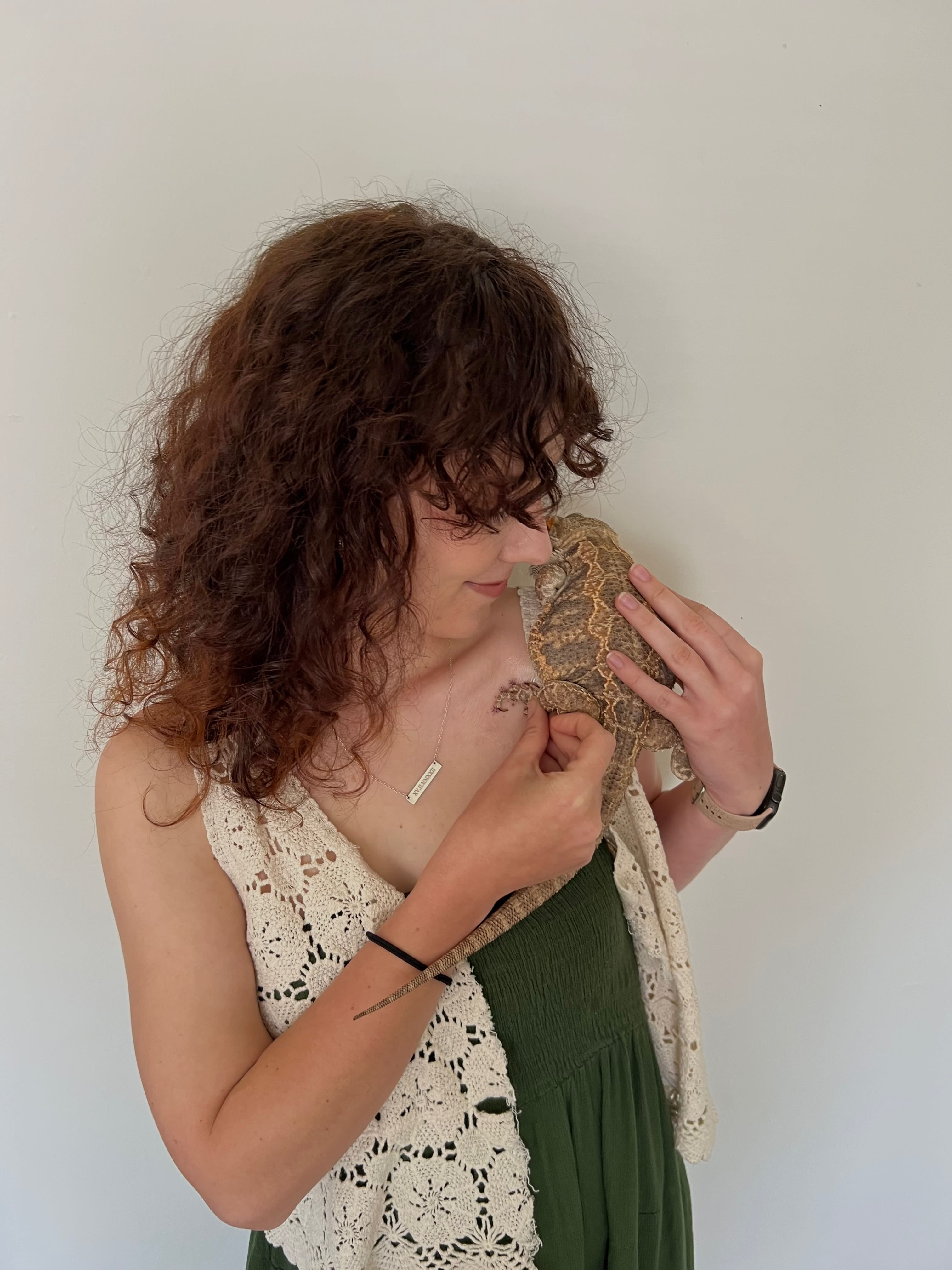 Swanger holds a lizard on her shoulder 