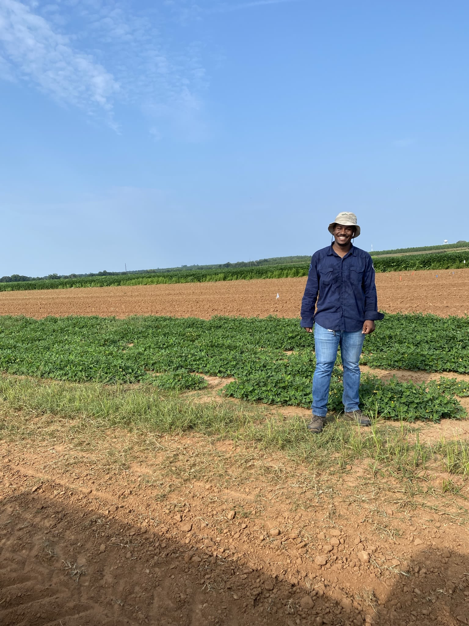 Perier wears a sun hat in a field