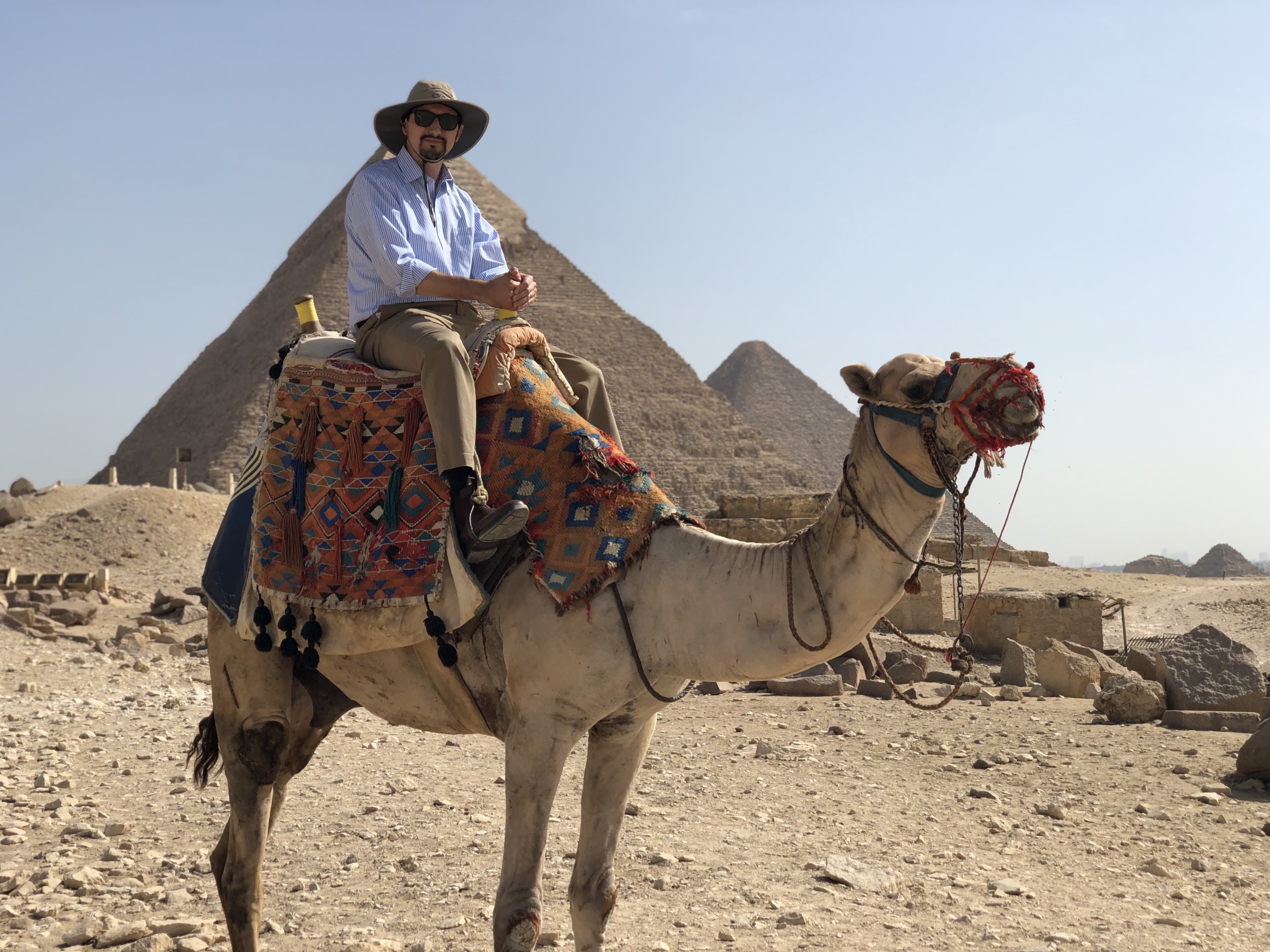 Lee Gross on a camel in front of Egyptian pyramids