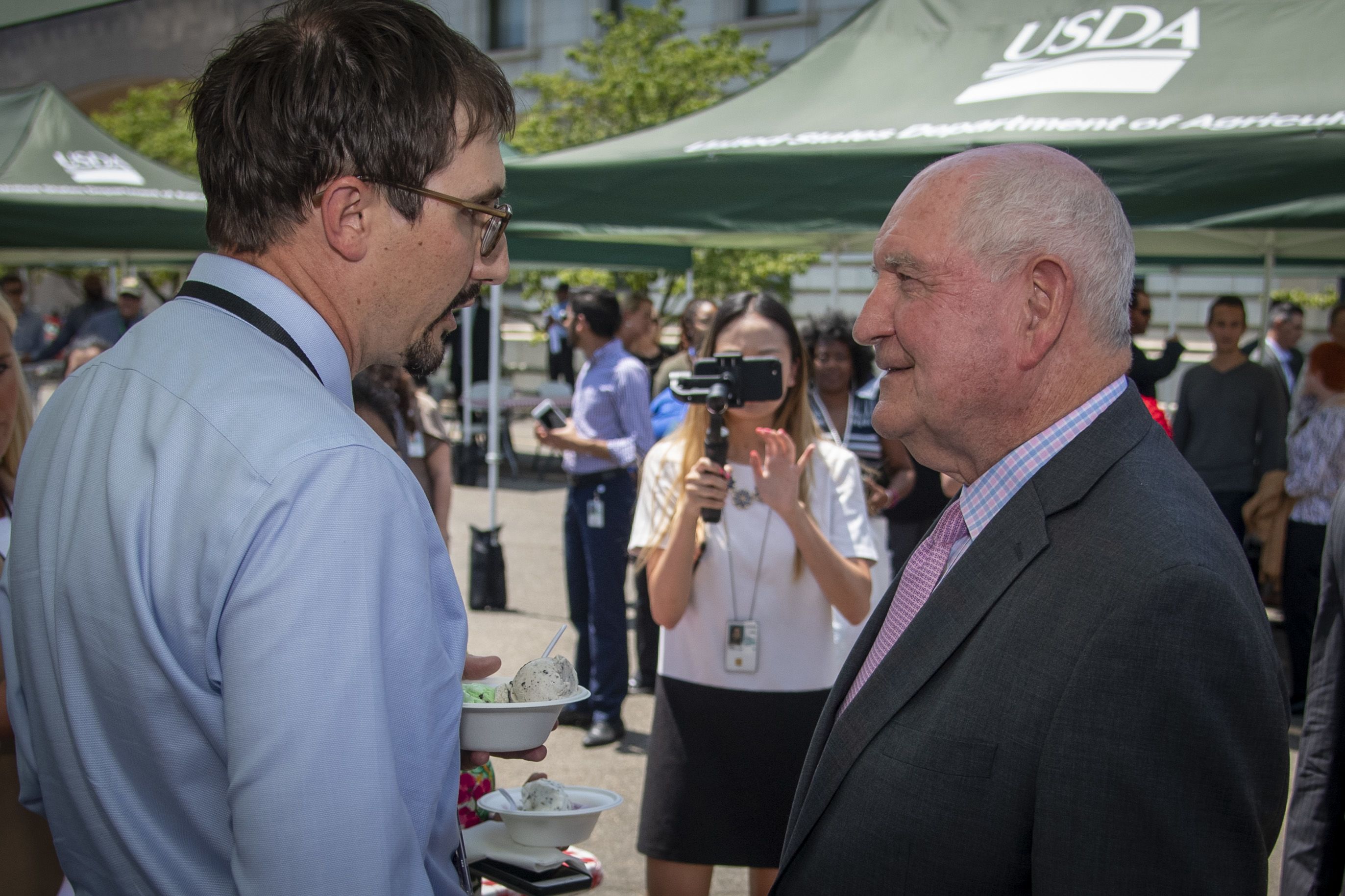 From the side, Lee Gross talks with then-Secretary of Agriculture Sonny Perdue.