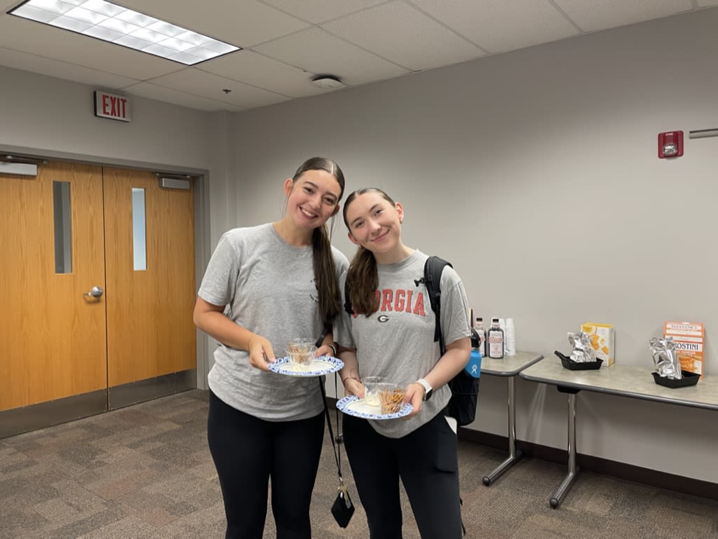 two students pose with plates of food from Dr.Critzer's Fermented food tasting party