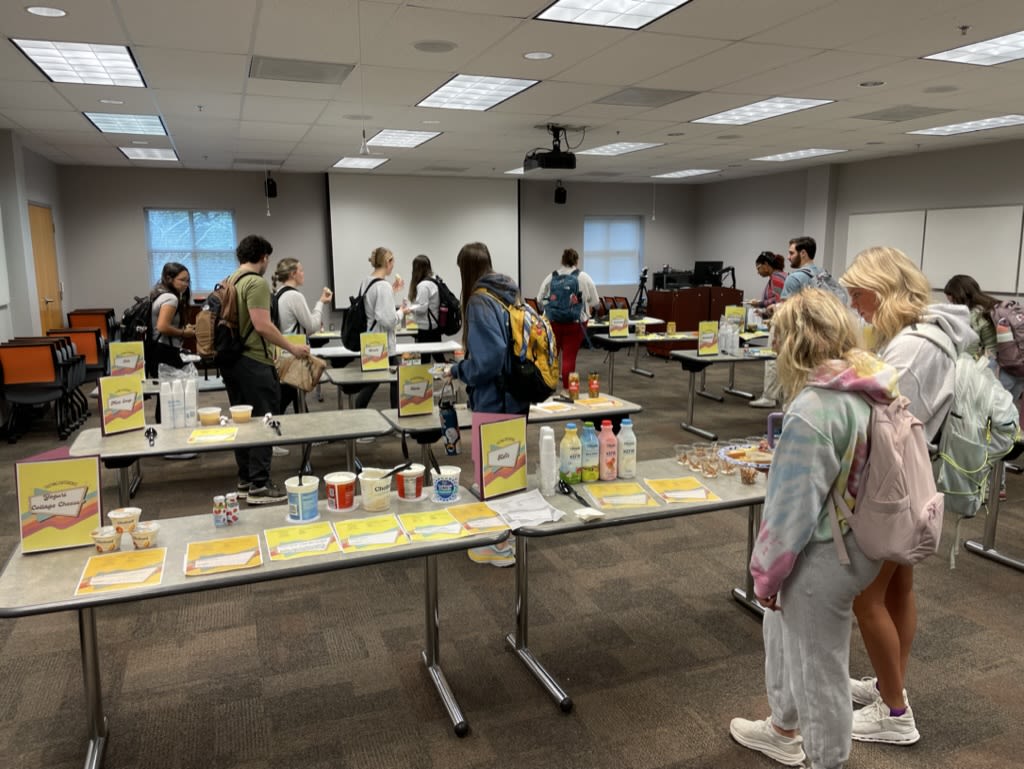 Students walk around to different tables to sample fermented foods, such as yogurt and kefi